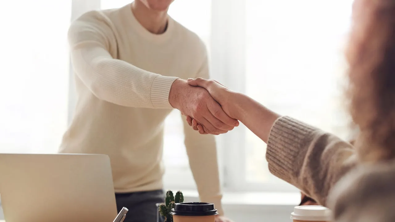 Groupe de personnes souriantes qui collaborent autour d'une table — citations positives en anglais