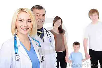 Deux médecins souriants devant une famille sur fond blanc.
