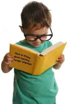 Enfant avec lunettes lisant un livre jaune sur l'apprentissage des langues.